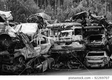 Dump of war-destroyed cars in Ukraine, black and white photo 92269707