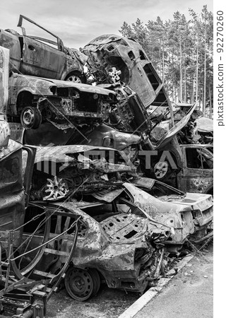 Dump of war-destroyed cars in Ukraine, black and white photo 92270260