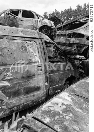 Dump of war-destroyed cars in Ukraine, black and white photo 92270711