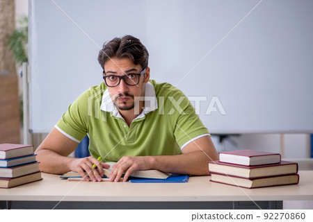Young male student preparing for exams in the classroom Young male student preparing for exams in the classroom 92270860