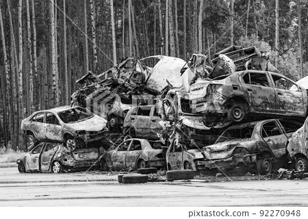 Dump of war-destroyed cars in Ukraine, black and white photo 92270948