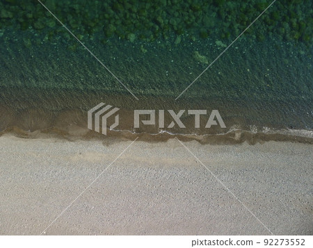 Aerial view on calm azure sea and volcanic rocky shores. Small waves on water surface in motion blur. Nature summer ocean sea beach background. Nobody. Holiday, vacation and travel concept Aerial view on calm azure sea and volcanic rocky shores. Small waves on water surface in motion blur. Nature summer ocean sea beach background. Nobody. Holiday, vacation and travel concept 92273552