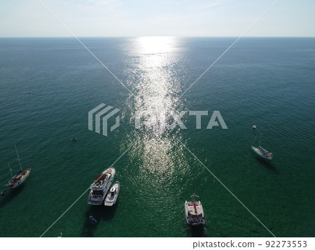 Aerial panoramic view of seascape with crystal clear azure sea and rocky shores. Yachts in a beautiful lagoon on backdrop of rocks. The concept of an ideal destination for summer travel and vacation. Aerial panoramic view of seascape with crystal clear azure sea and rocky shores. Yachts in a beautiful lagoon on backdrop of rocks. The concept of an ideal destination for summer travel and vacation. 92273553