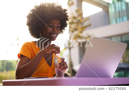 Happy beautiful young black woman using laptop in cafe Happy beautiful young black woman using laptop in cafe 92275088