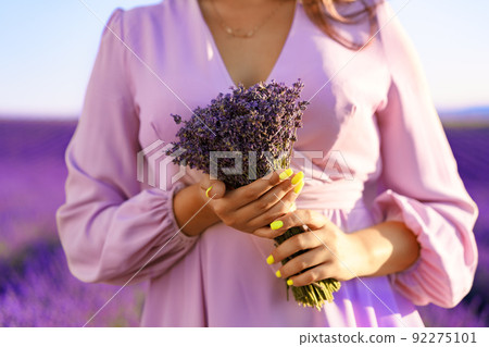 Close up of a woman in lilac dress in lavender field Close up of a woman in lilac dress in lavender field 92275101