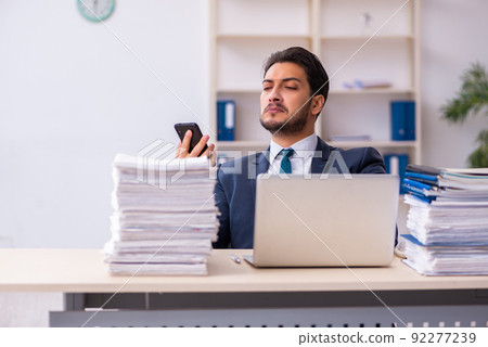 Young businessman employee and too much work in the office Young businessman employee and too much work in the office 92277239