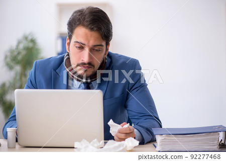 Young male employee suffering at workplace 92277468