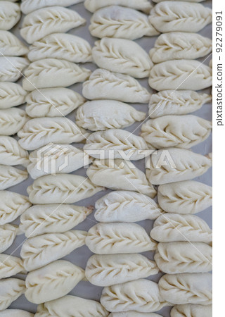 Dumplings with minced meat and dough on table sprinkled with flour. Dumplings with minced meat and dough on table sprinkled with flour. 92279091