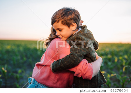 Loving smiling son hugs mom tightly. Tender family scene. Cute 3 year old ukrainian kid with mother 92279604