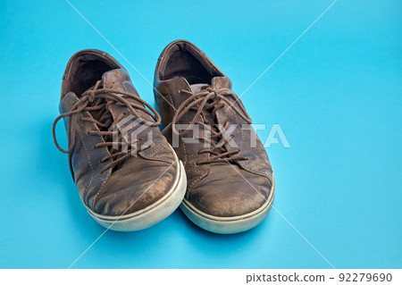 Beautifully aged vintage brown leather boots isolated on blue background with copy space 92279690