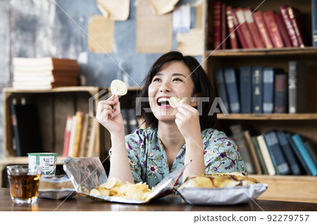 A woman eating potato chips 92279757