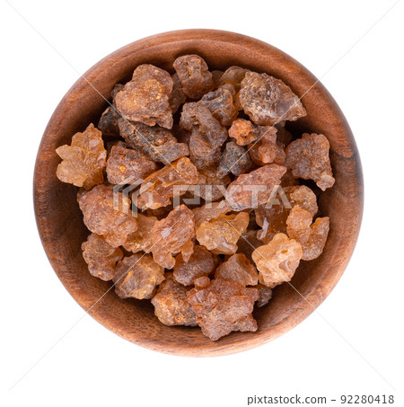 Myrrh resin in wooden bowl, isolated on white background. Pile of natural Commiphora myrrha. Sweet Myrrh Opoponax. Incense. Top view. 92280418