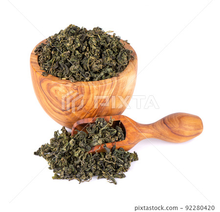 Dry gynostemma pentaphyllum leaf in olive bowl and spoon, isolated on white blackground. Jiaogulan or Miracle grass. Chinese herbal tea. Dry gynostemma pentaphyllum leaf in olive bowl and spoon, isolated on white blackground. Jiaogulan or Miracle grass. Chinese herbal tea. 92280420