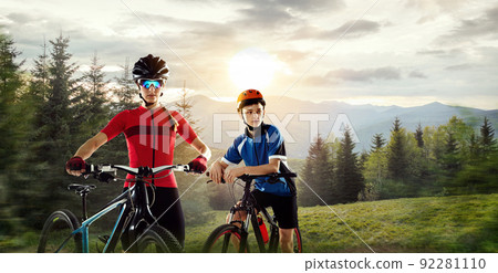 Portrait of young woman and teen boy riding at forest on a bicycle. Nature landscape Portrait of young woman and teen boy riding at forest on a bicycle. Nature landscape 92281110