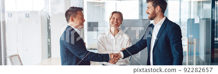 Young happy leader shaking hand with businessman for congratulation success presentation new project 92282657