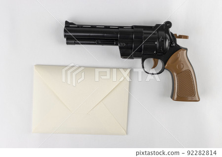 A toy gun and a letter envelope. Image of crime notice A toy gun and a letter envelope. Image of crime notice 92282814