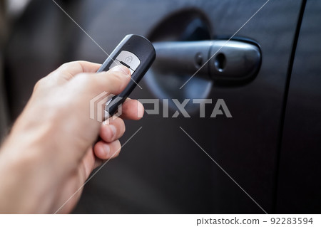 The car owner holds in his hand a remote control device for keyless entry. Close-up, selective focus 92283594