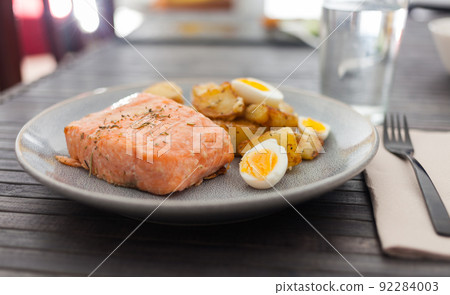 steamed salmon fillet with potato wedges and quail egg 92284003