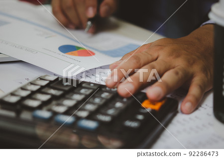 businessman holding calculators and business documents charts statistical data investment analysis and tax accounting. 92286473