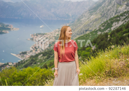 Woman tourist enjoys the view of Kotor. Montenegro. Bay of Kotor, Gulf of Kotor, Boka Kotorska and walled old city. Travel to Montenegro concept. Fortifications of Kotor is on UNESCO World Heritage 92287146
