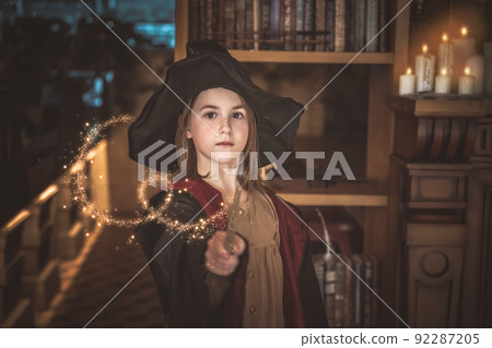 a girl in a black hat and robe and magic wands 92287205