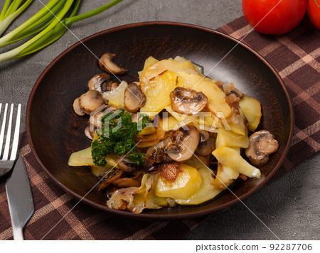 fried potatoes with mushrooms and onions decorated with herbs 92287706
