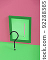 Black question mark and pink exclamation mark in mirror on pink and green background. 92288365
