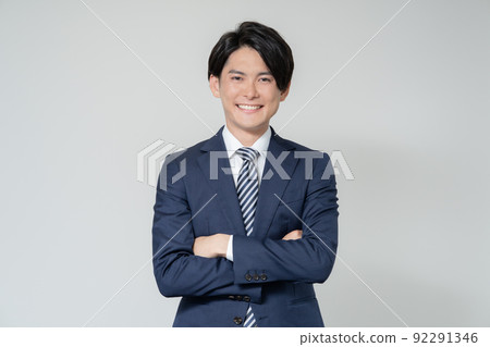 一個年輕商人的肖像，雙臂交叉在白色背景上 92291346