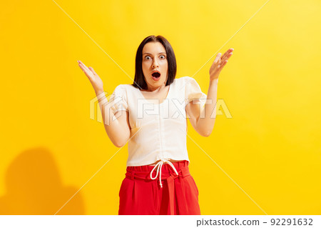 Studio shot of young beautiful woman in summer casual style outfit isolated on bright yellow background. Concept of beauty, art, fashion, human emotions 92291632