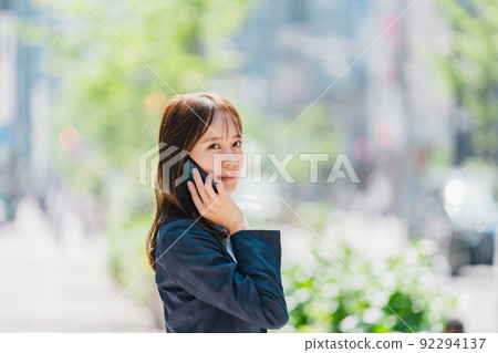 Business woman with a smartphone outdoors 92294137