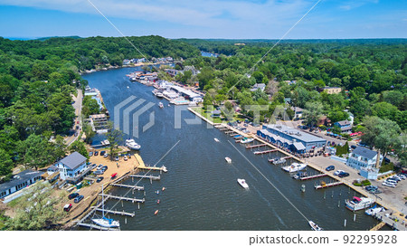 Boats sailing in lake from above with docks and green forest Boats sailing in lake from above with docks and green forest 92295928