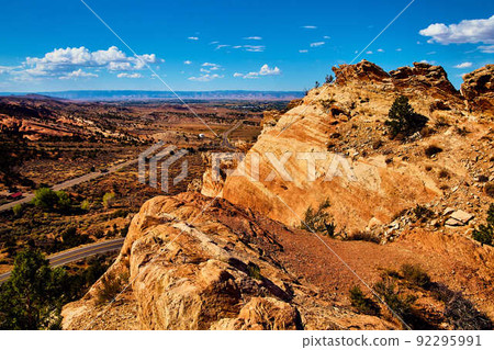 Road through large rocks with mountain view Road through large rocks with mountain view 92295991