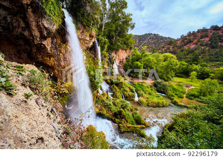 Landscape of beautiful large waterfalls with park trail and tourists 92296179
