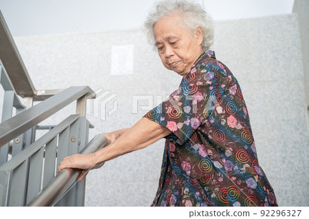 Asian senior or elderly old lady woman patient use handle at stairs security support in building, healthy strong medical concept. 92296327
