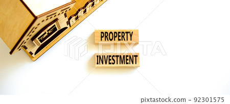 Property investment symbol. Concept words Property investment on wooden blocks on a beautiful white table white background. Wooden house model. Business Property investment concept. Copy space. 92301575