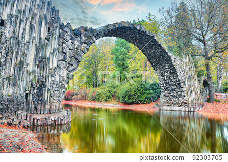 Unbelievable autumn landscape in Azalea and Rhododendron Park Kromlau. Rakotz Bridge (Rakotzbrucke, Devil's Bridge) Unbelievable autumn landscape in Azalea and Rhododendron Park Kromlau. Rakotz Bridge (Rakotzbrucke, Devil's Bridge) 92303705