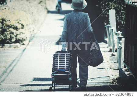 Back view of shopping carry and senior woman 92304995