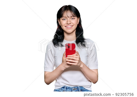 Portrait of young female with smartphone looking at camera, on white background Portrait of young female with smartphone looking at camera, on white background 92305756