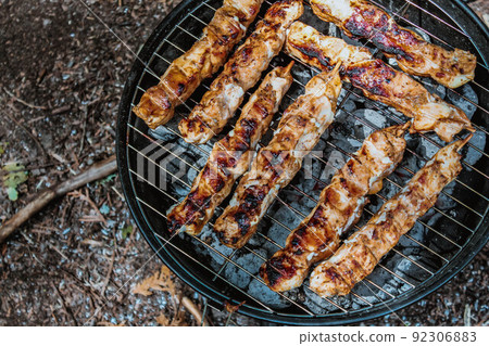 Summer grilling food, sausage, vegetables and kebab meat on barbecue grill over smoke and hot charcoal 92306883