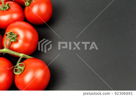 Red tomatoes on black background with water drops 92306891