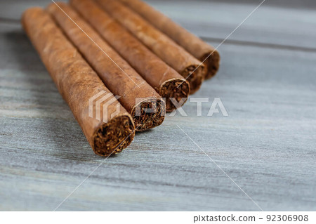 Many cigars on the wooden background. Rolled cigars 92306908