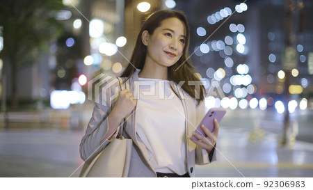Business woman looking at a smartphone on the way home from work Female smartphone 92306983