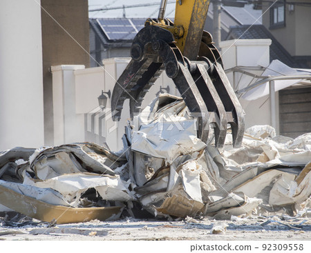 Dismantling work using a shovel car. Demolition of the building. Debris removal. Dismantling work using a shovel car. Demolition of the building. Debris removal. 92309558