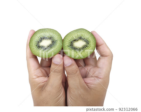 Hand holds sliced half of kiwi fruit isolated on white background Hand holds sliced half of kiwi fruit isolated on white background 92312066