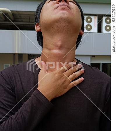 Asian young men have a sore throat caused by cold weather. Medical and healthcare concept. 92317939