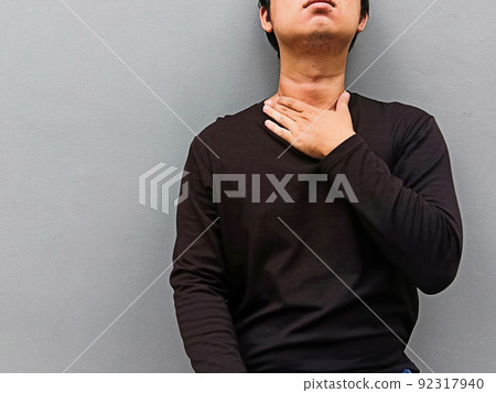 Asian young men have a sore throat. Medical and healthcare concept. Asian young men have a sore throat. Medical and healthcare concept. 92317940