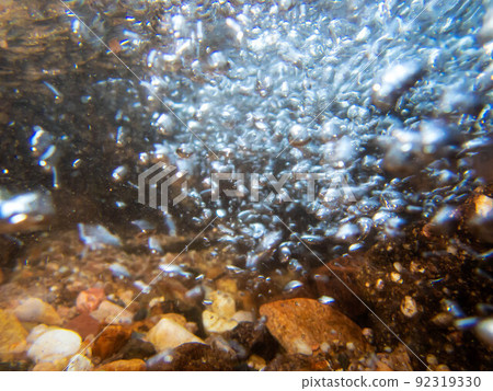 Underwater abstract image of a bubbles in stream with colorful stones Underwater abstract image of a bubbles in stream with colorful stones 92319330