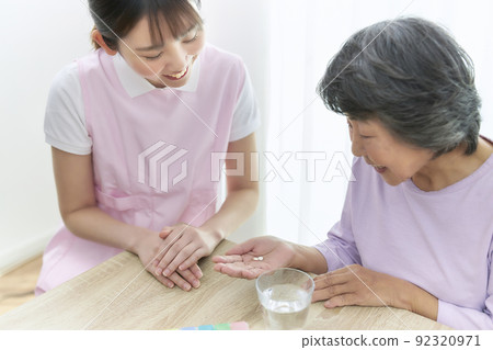 Young caregiver teaching medicine to senior women Young caregiver teaching medicine to senior women 92320971