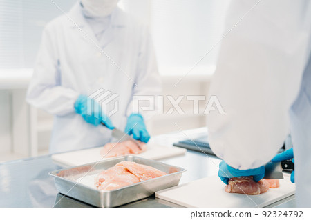 Men and women working in meat processing Men and women working in meat processing 92324792