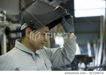 工廠裡戴著焊接面罩的男工 92326619